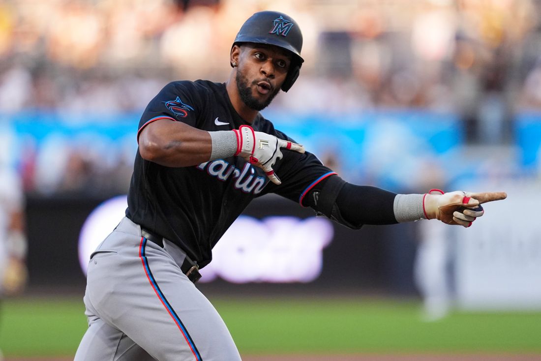 A Marlins hitter pointing as he rounds the bases