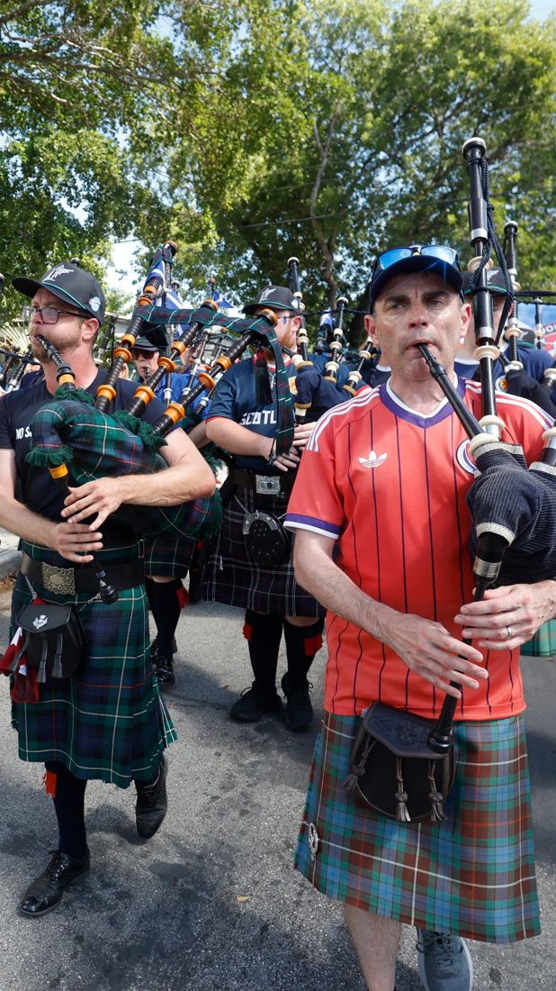 Tartan Army bagpipers in kilts and Marlins caps marching to loanDepot park