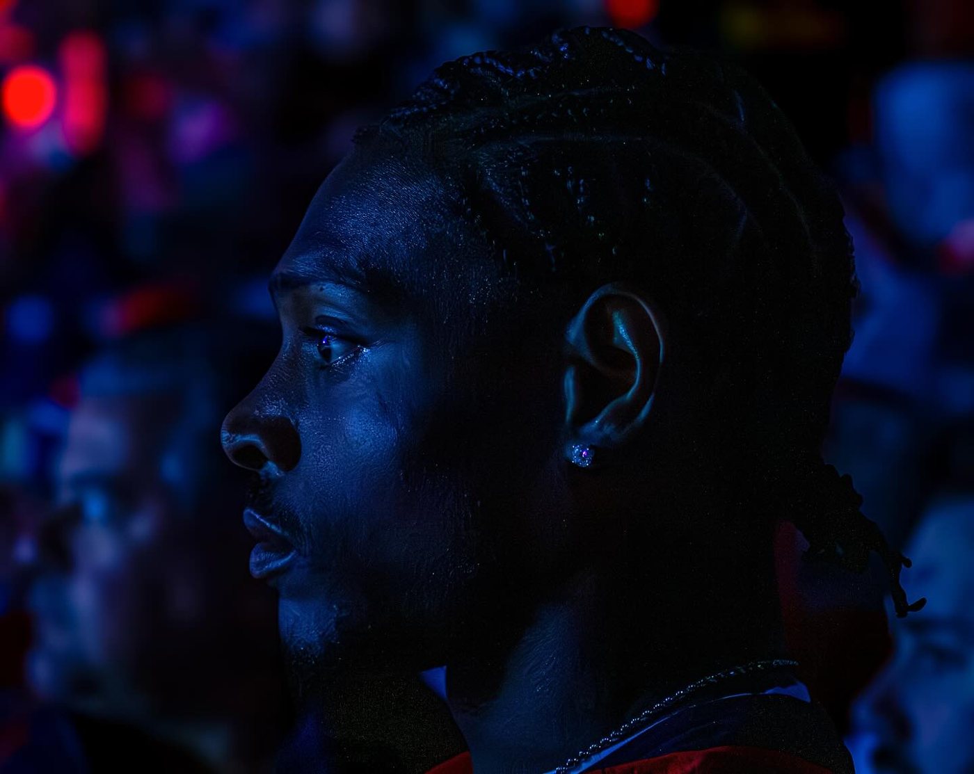 A basketball player in profile lit in deep blue