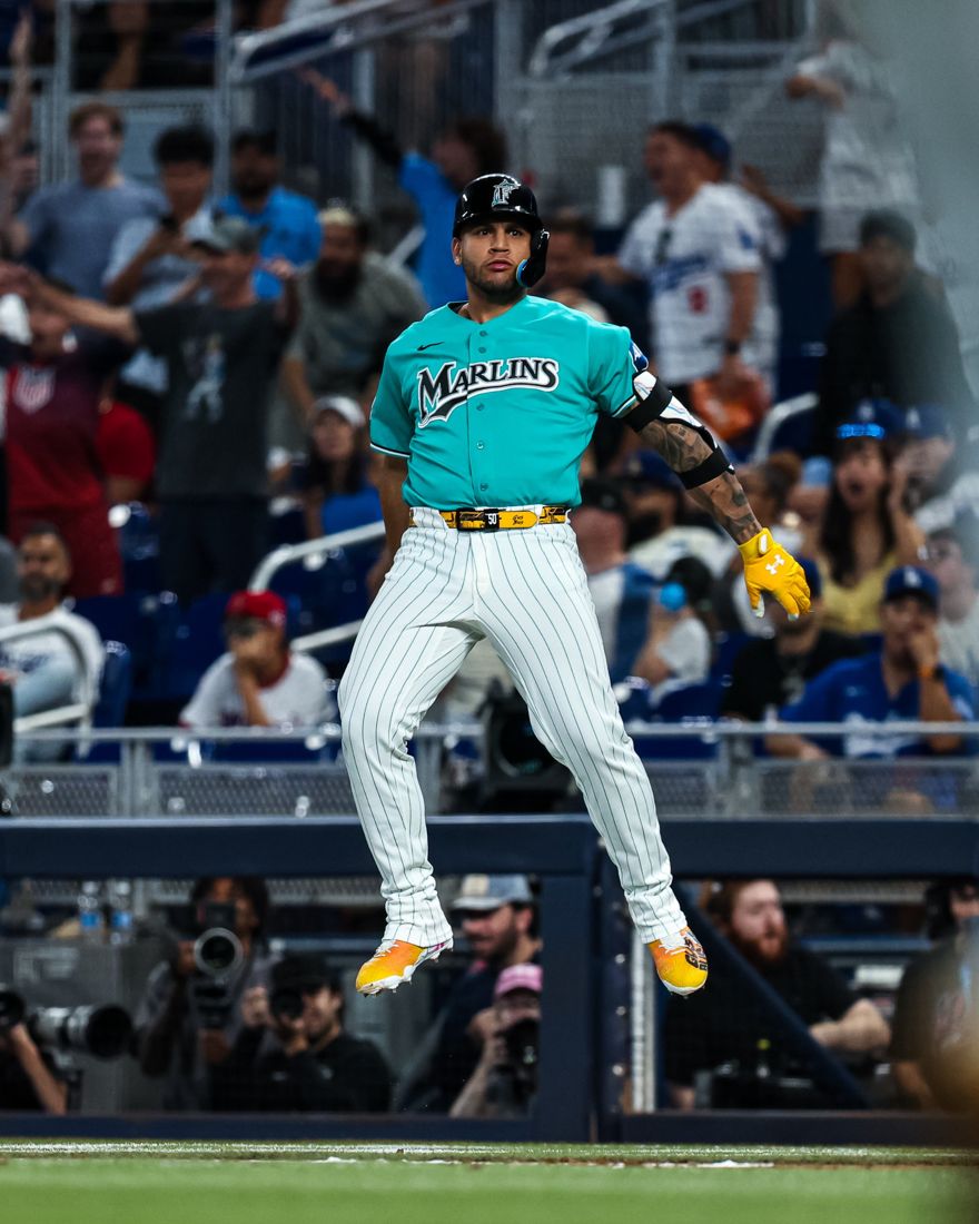 Agustín Ramírez leaping off the bag in a teal Marlins jersey
