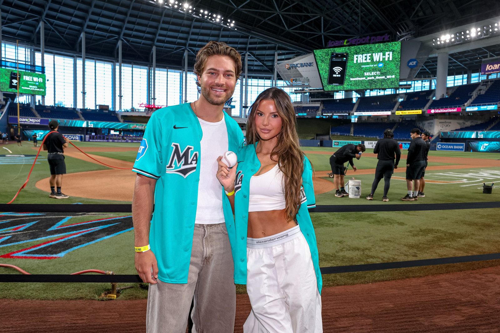 Two creators in Marlins jerseys on the field at loanDepot park