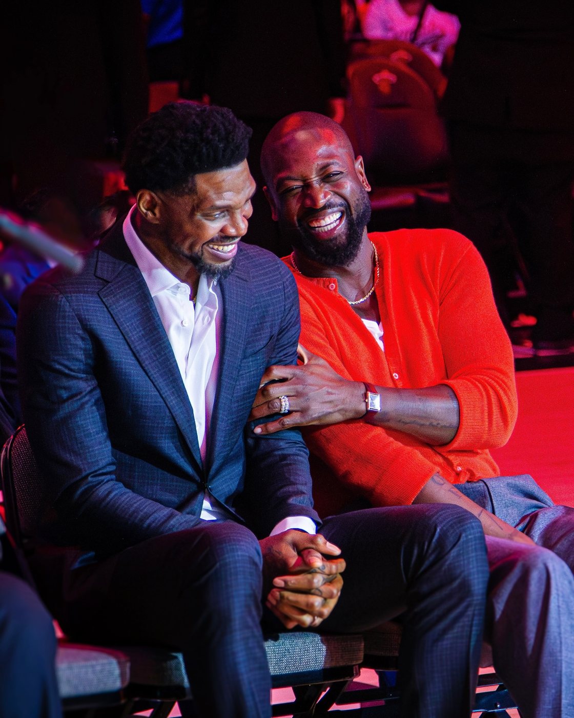 Udonis Haslem and Dwyane Wade laughing together courtside under red light